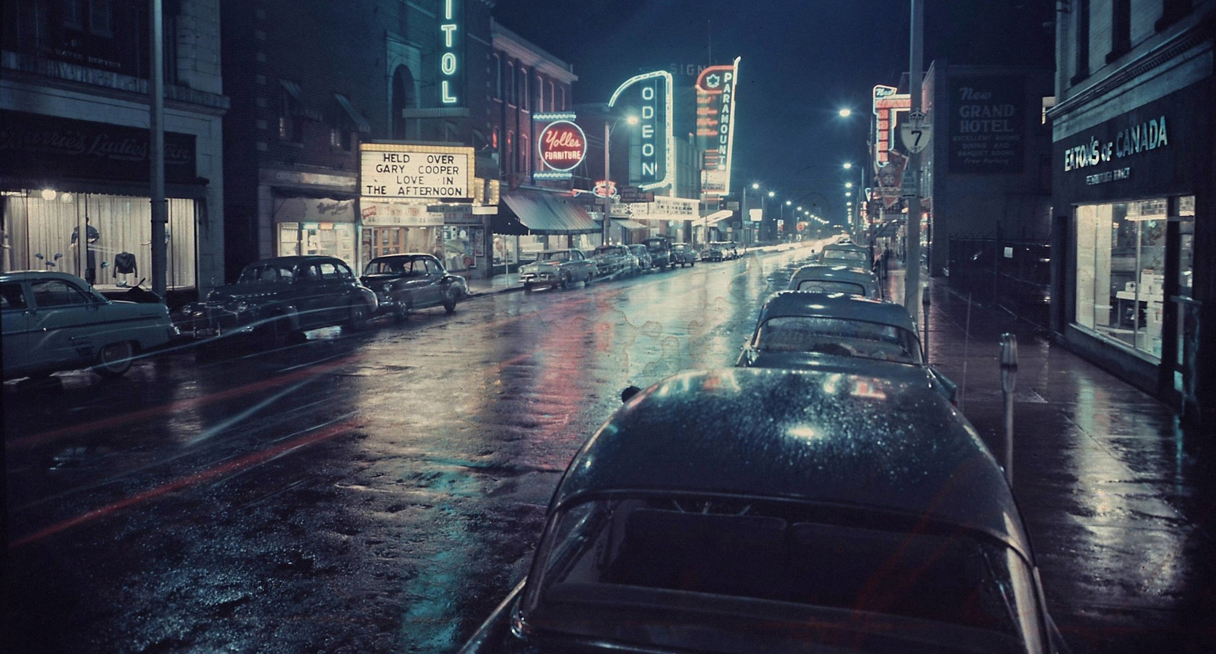Nighttime photo of downtown street with neon signs on buildings