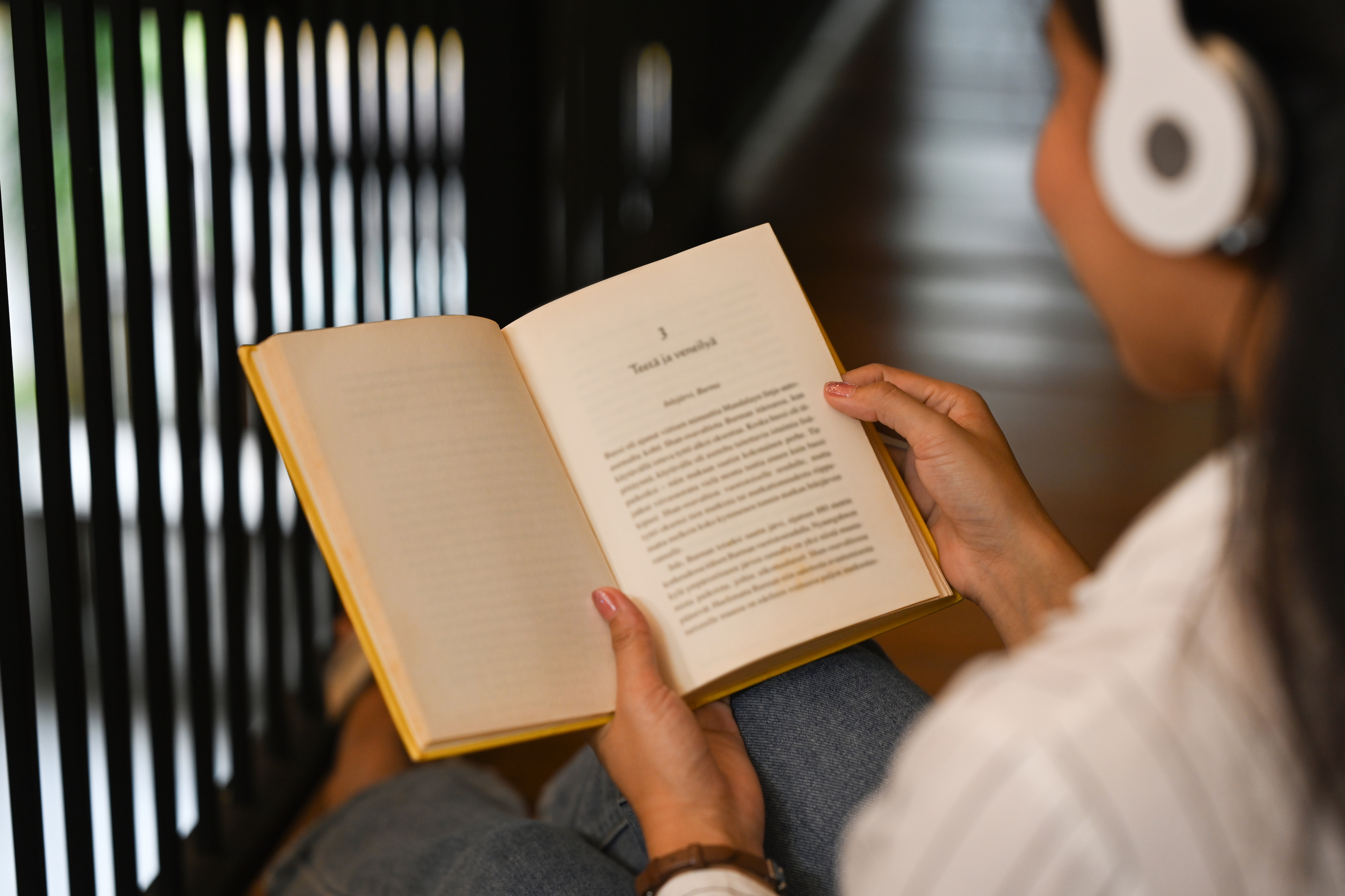 Over Shoulder View Of Young Woman Wearing Headphones