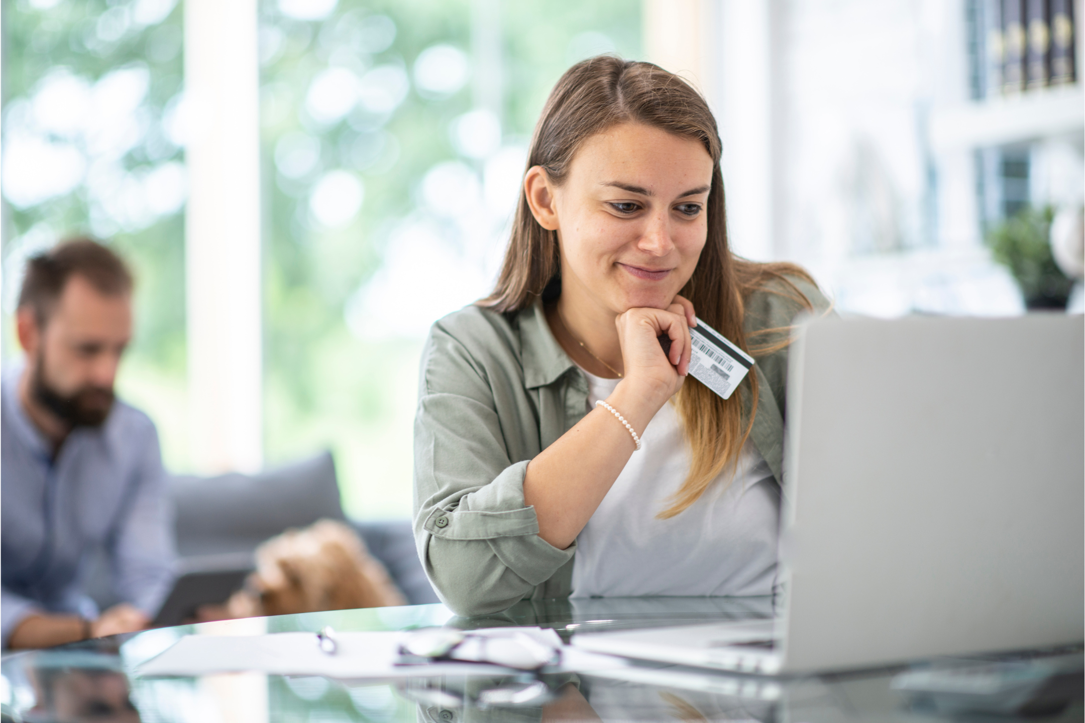 Woman at laptop holding credit card