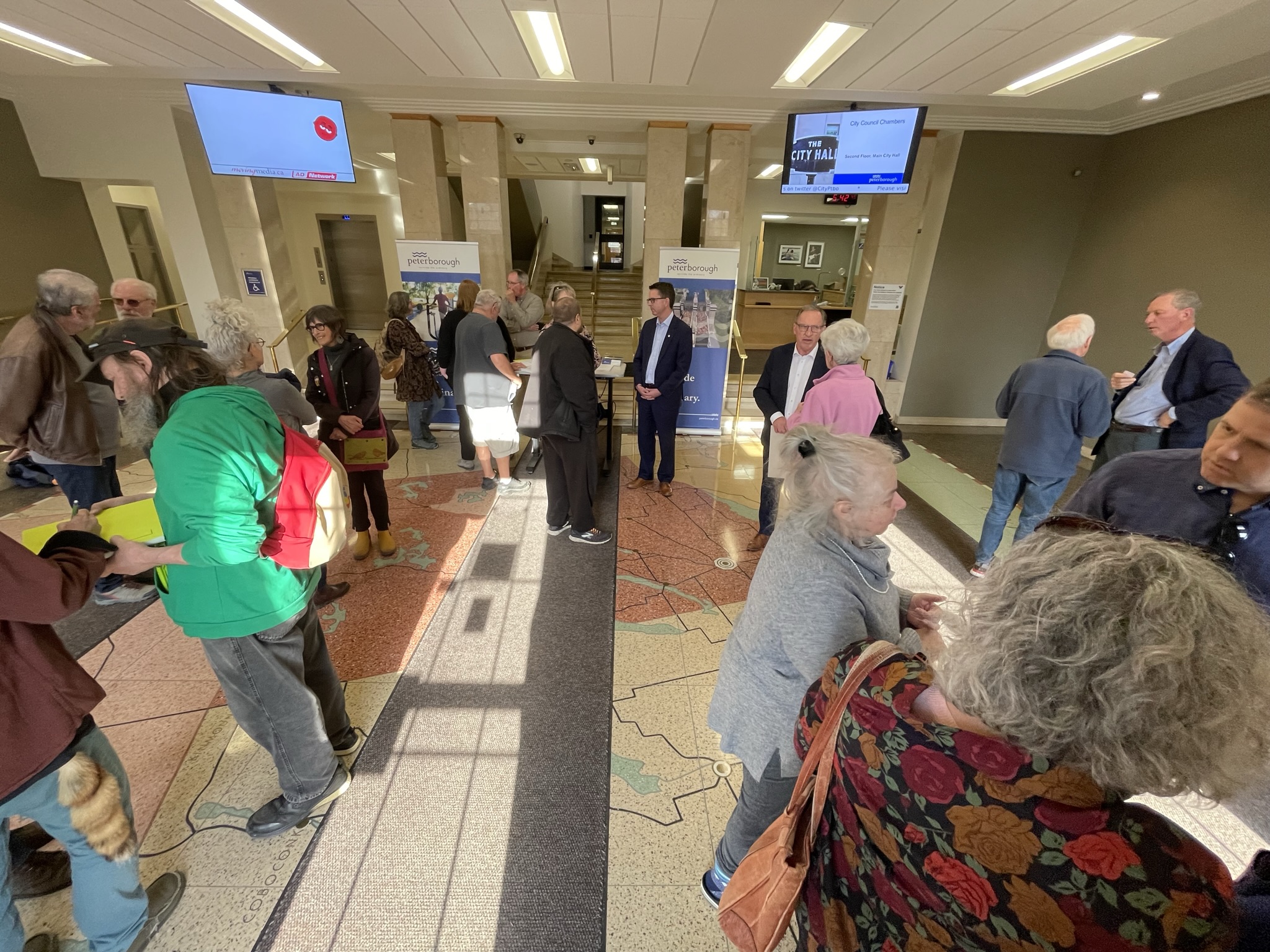 People in a foyer speaking in groups
