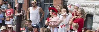 Crowd dressed in red and white watching the Canada Day parade