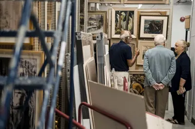 Group of people standing in room with art stored 