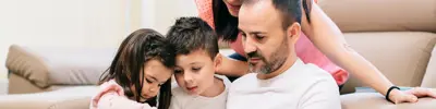 Two adults with two children looking at a tablet
