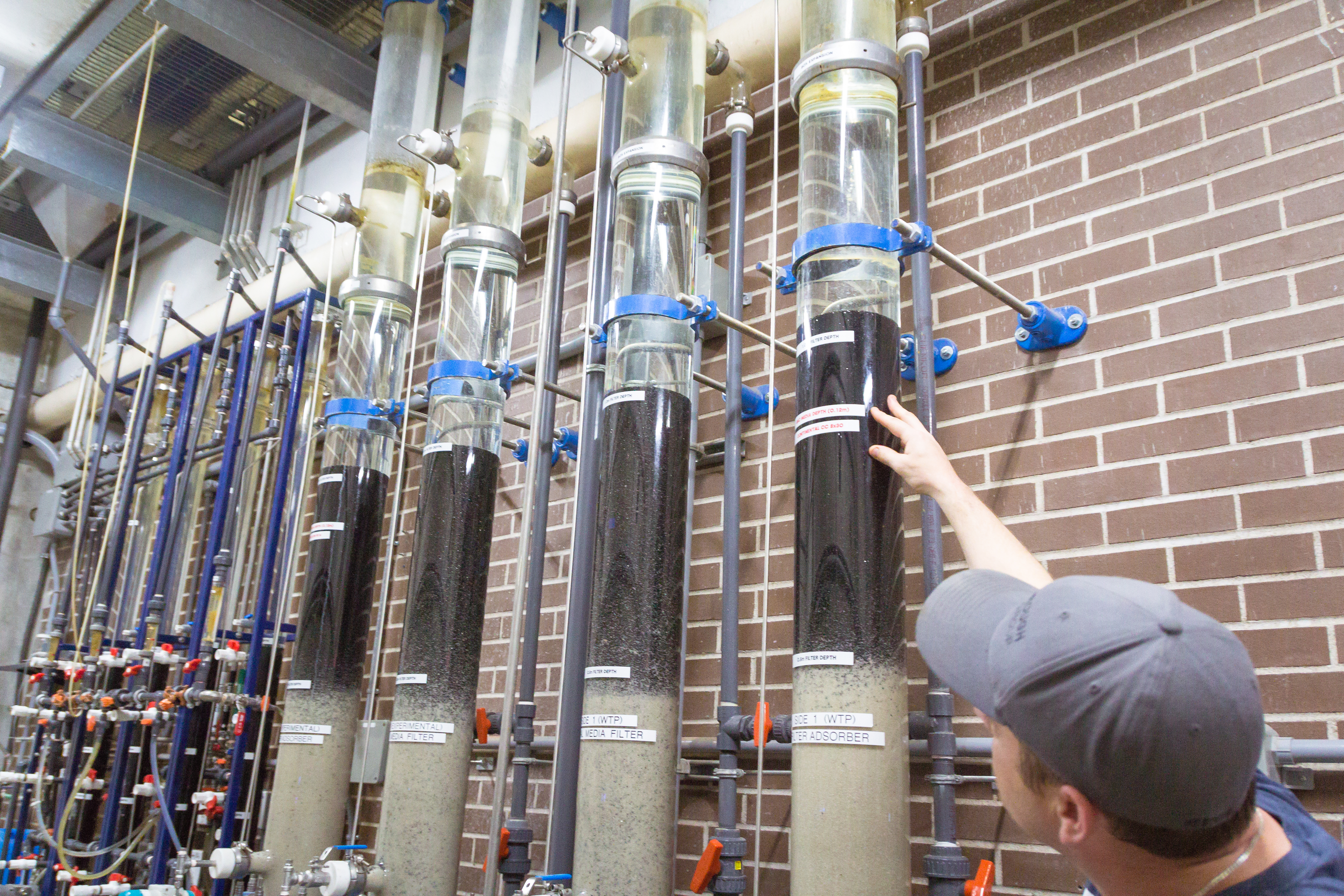 Person standing next to equipment in a water treatment plant