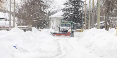 A plow clears a snow-filled residential street