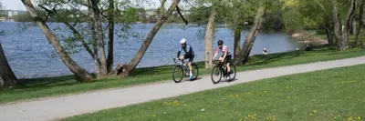 Two people cycling on Rogers Cove trail