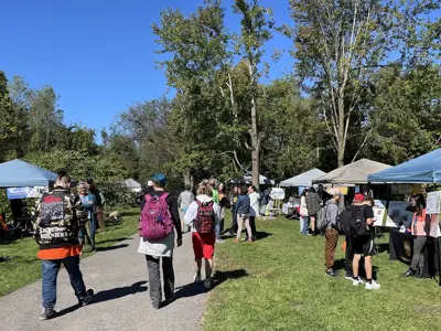The park is full of information booths and people visiting on a sunny day