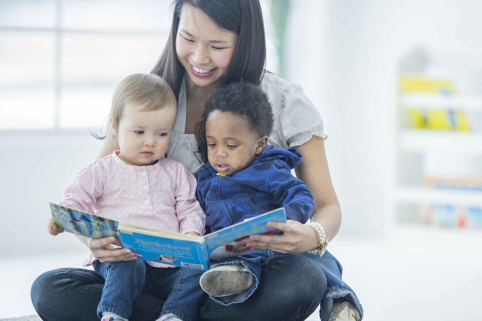 Woman reading a story to two small children