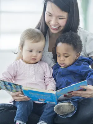 Woman reading a story to two small children